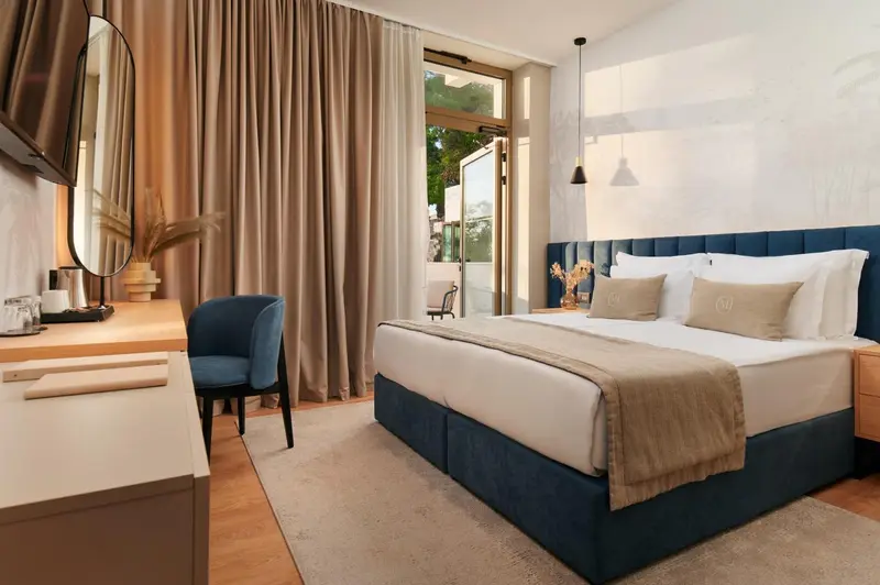 Une chambre lumineuse avec un grand lit et un coin salon.