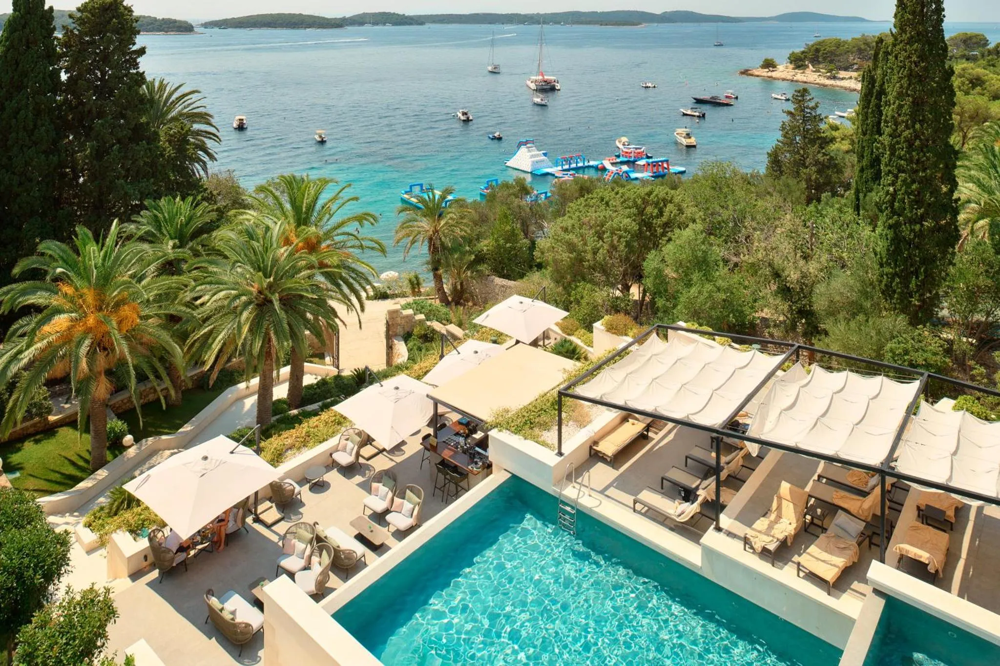 Terrasse avec transats et piscine surplombant la mer.