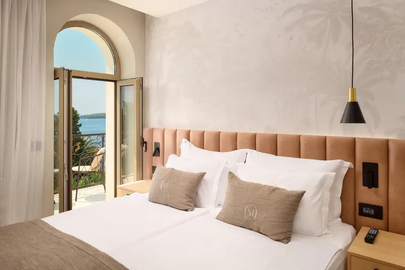 Une chambre lumineuse avec un grand lit et une vue sur la mer.