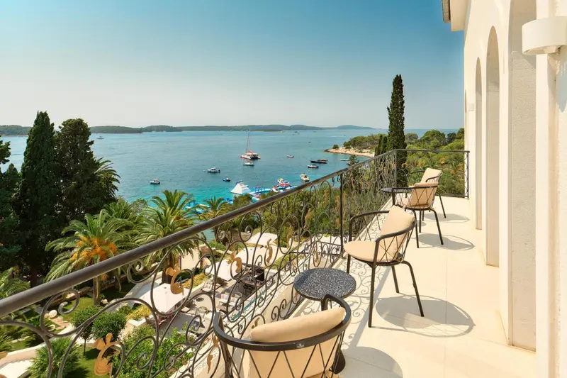 Terrasse avec mobilier d'extérieur donnant sur une vue mer et des bateaux.