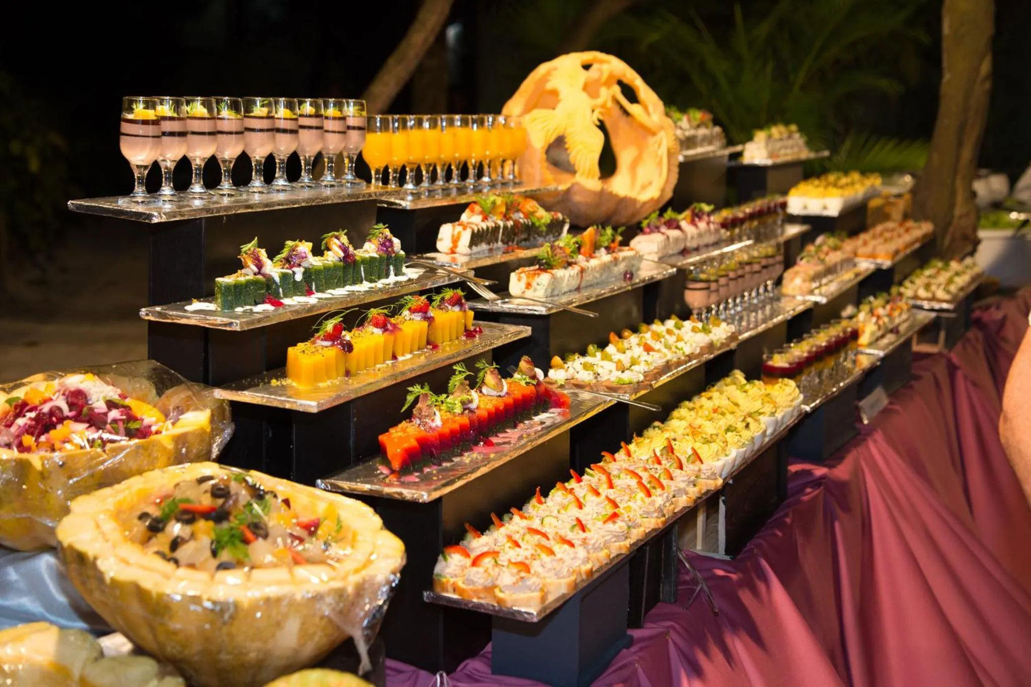 Un buffet propose une grande variété de plats colorés et de boissons.