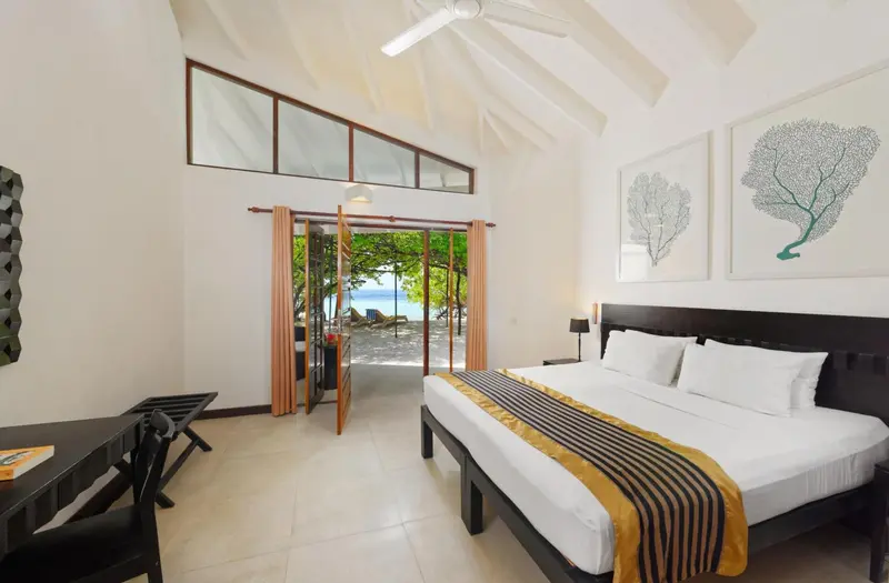 Une chambre lumineuse avec un grand lit et vue sur la mer.
