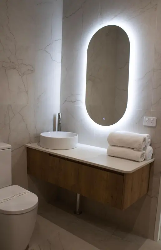 Une salle de bain moderne avec un lavabo et un miroir lumineux.