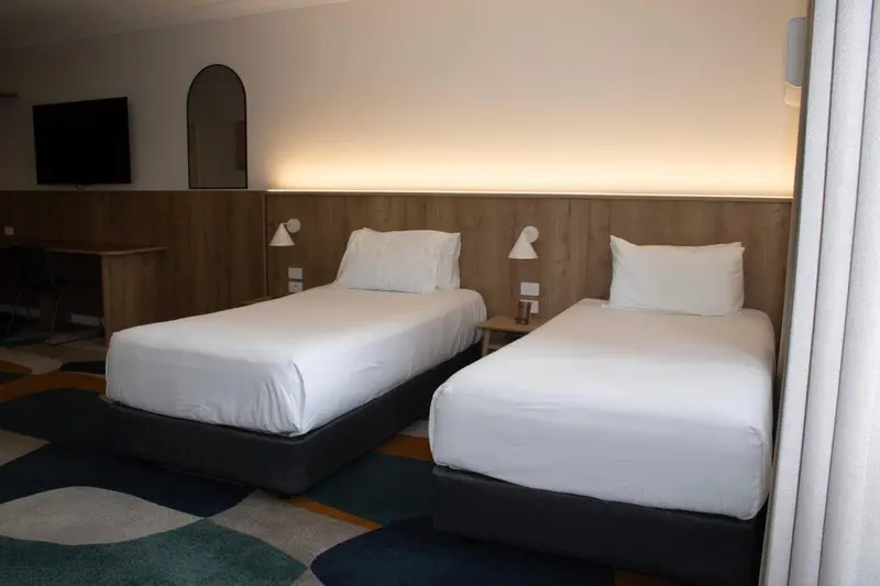 Une chambre avec deux lits simples et une décoration moderne.