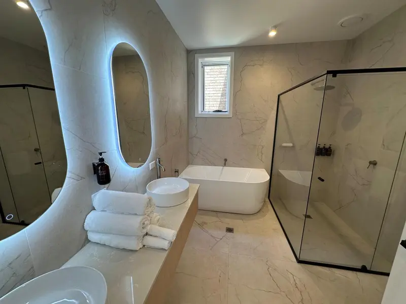 Une salle de bain moderne avec baignoire et douche à l'italienne.