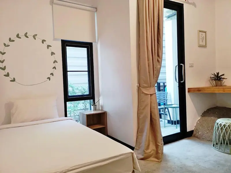 Une chambre lumineuse avec un lit et un accès à une terrasse.