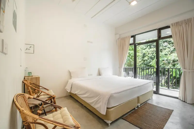 Une chambre lumineuse avec un grand lit et un accès à une terrasse.