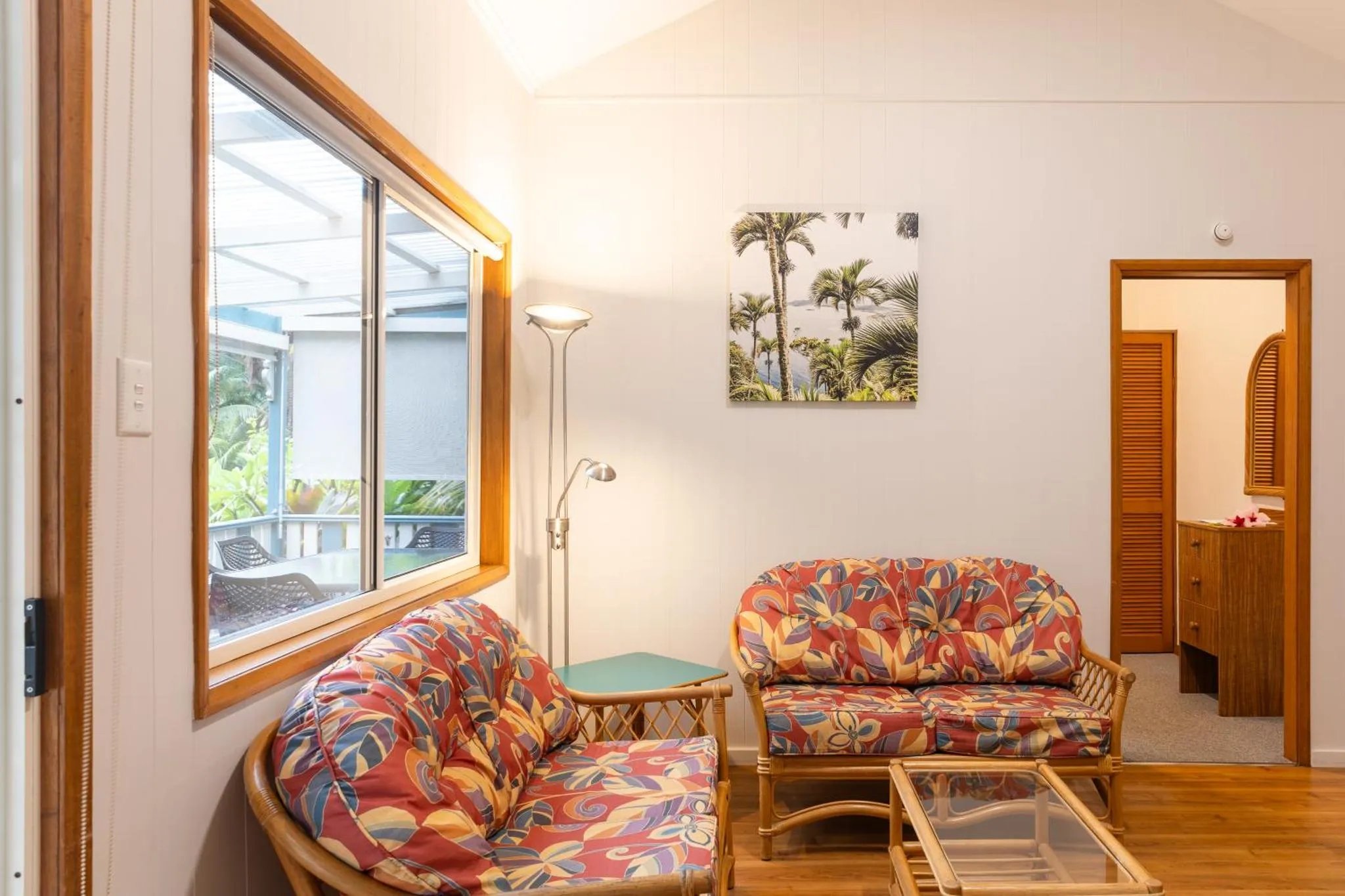 Espace de détente lumineux avec canapés et décoration tropicale.