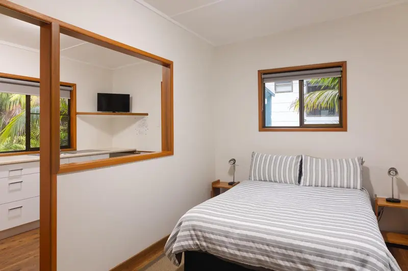 Une chambre lumineuse avec un lit et une télévision.