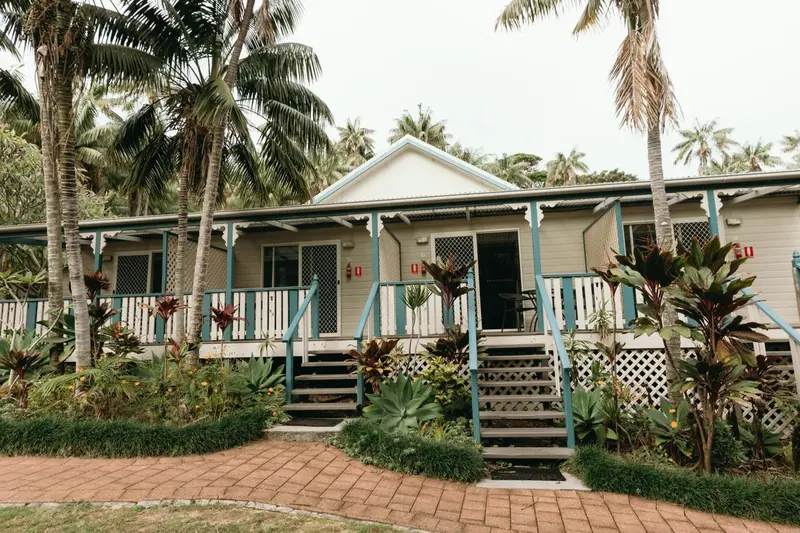 Façade d'un bâtiment avec des terrasses et une végétation tropicale.