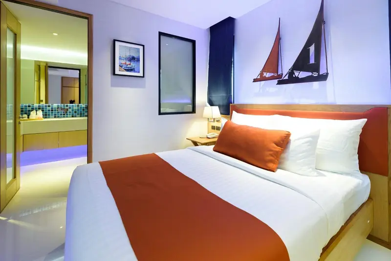 Une chambre lumineuse avec un grand lit et une décoration marine.