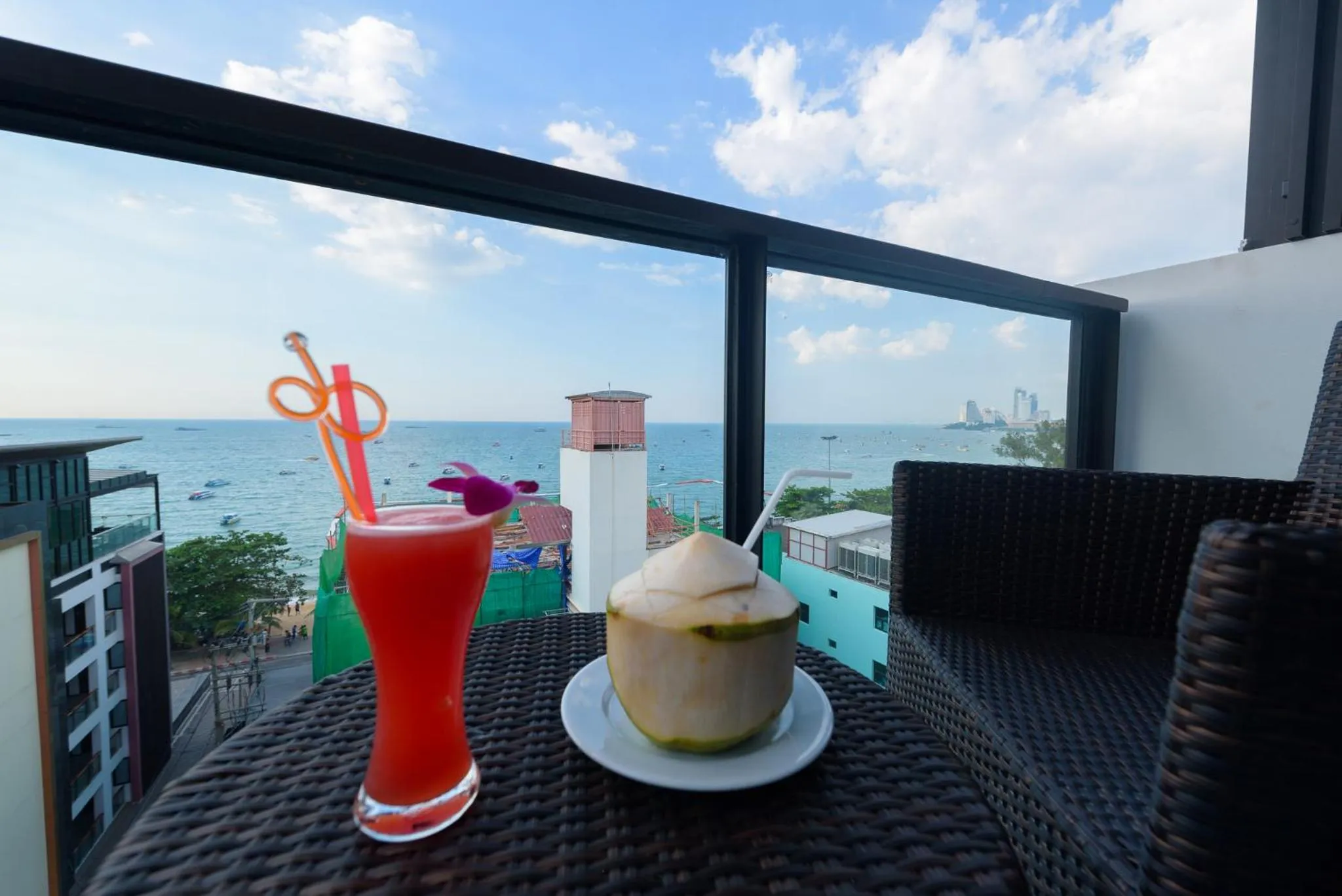 Deux boissons exotiques sur une table de balcon avec vue sur la mer.