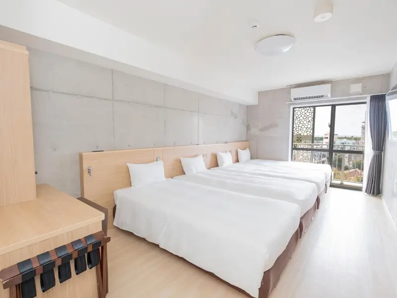 Une chambre lumineuse avec deux lits simples et une fenêtre.