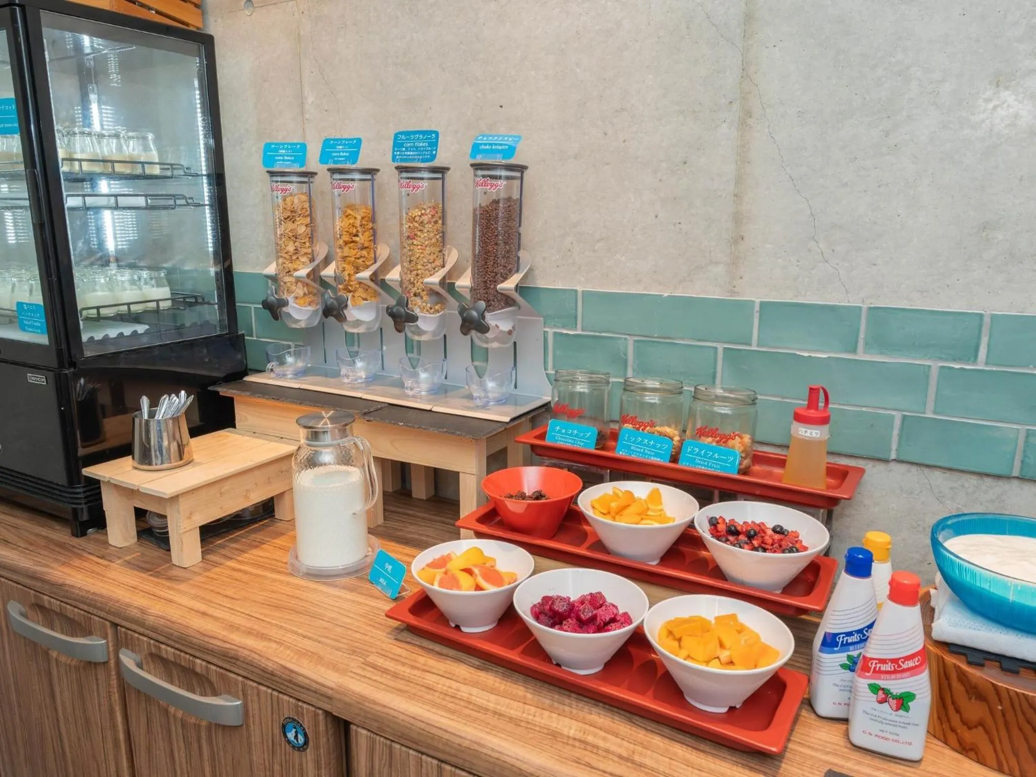 Un buffet propose des céréales, des fruits frais et des boissons.