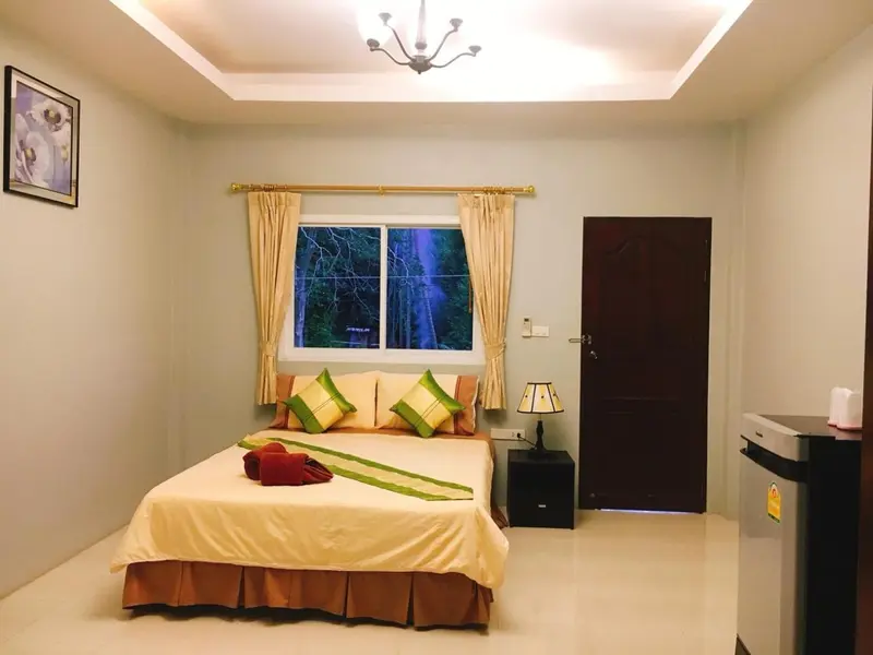 Une chambre lumineuse avec un grand lit et des rideaux décoratifs.