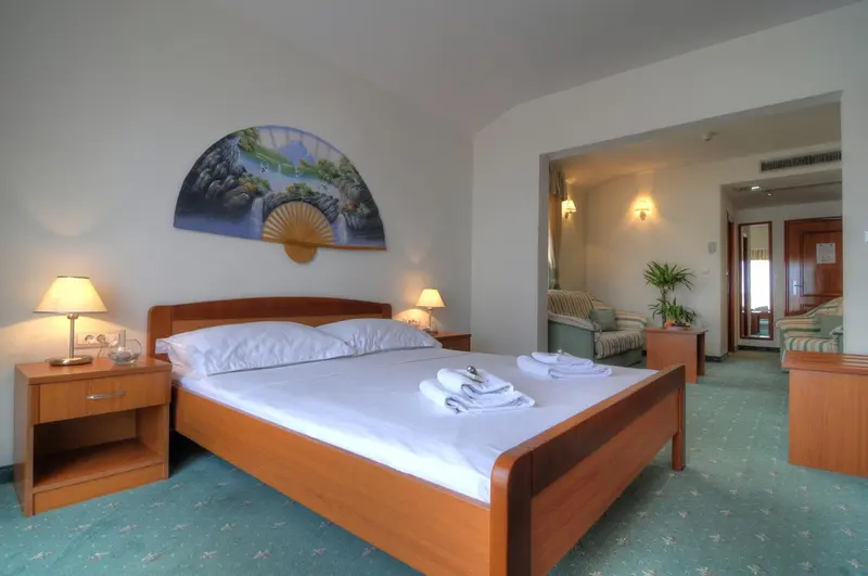 Une chambre lumineuse avec un grand lit et un espace salon.