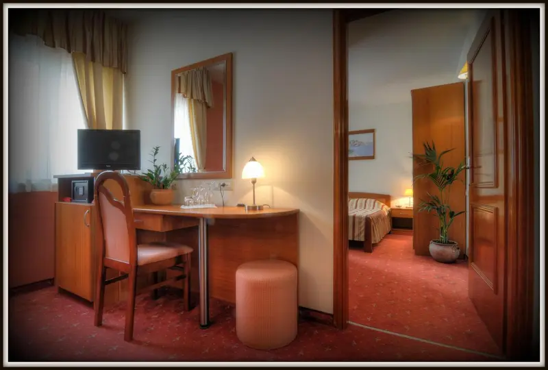 Une chambre d'hôtel avec un bureau et un accès vers une autre pièce.