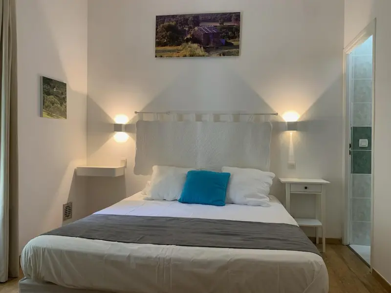 Une chambre lumineuse avec un grand lit et des tables de chevet.