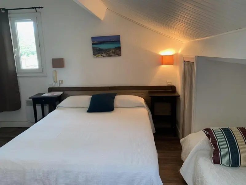 Une chambre lumineuse avec un lit double et une vue sur la mer.