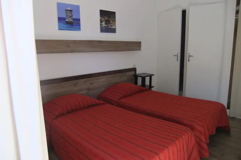 Une chambre avec deux lits simples et une décoration murale.