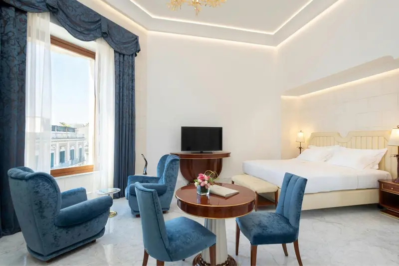 Une chambre lumineuse avec un lit double et un coin salon.