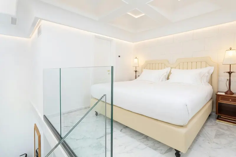 Une chambre lumineuse avec un grand lit recouvert de draps blancs.