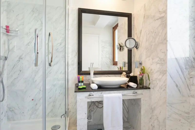 Une salle de bain moderne avec une douche vitrée et un lavabo sur un meuble sombre.
