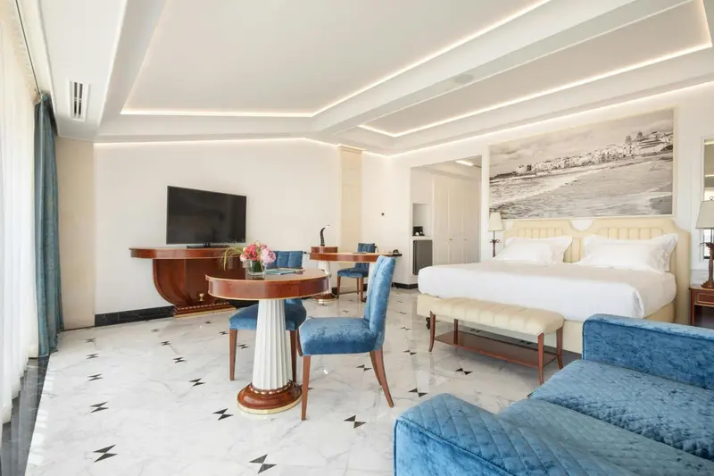 Une chambre lumineuse avec un coin repas et un grand lit.