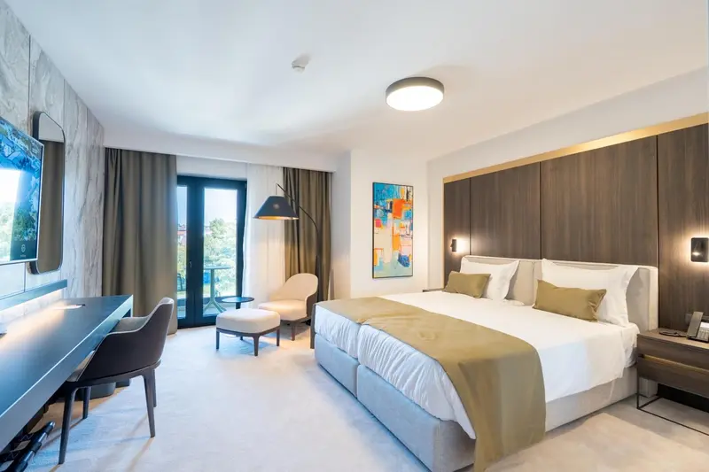 Chambre lumineuse avec un grand lit et un espace détente.