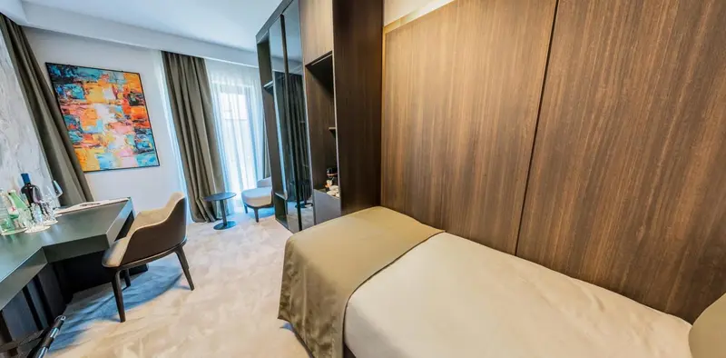 Une chambre moderne avec un bureau, un lit et une décoration murale colorée.