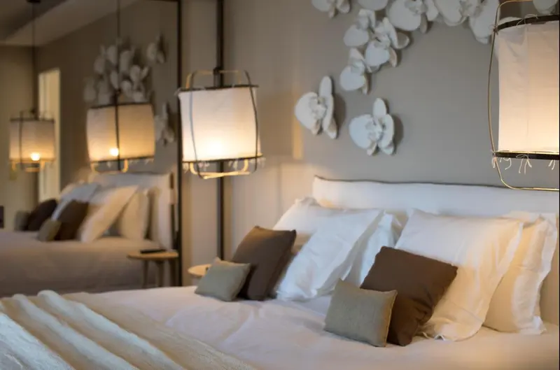 Lits préparés avec oreillers et couvertures blanches dans une chambre d'hôtel.