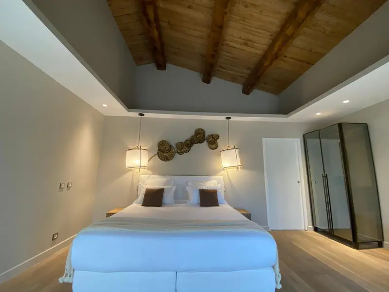 Une chambre lumineuse avec un grand lit et une décoration murale.