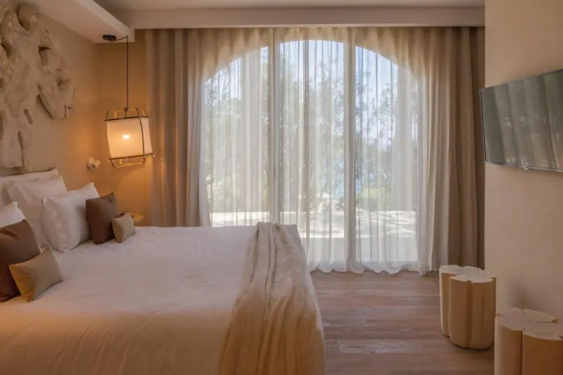Une chambre lumineuse avec un grand lit et une vue sur la mer.
