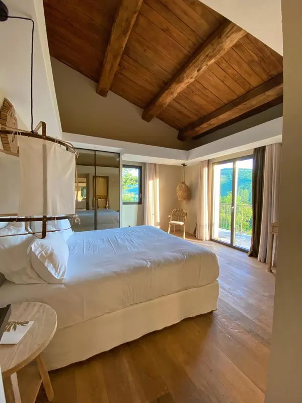 Une chambre lumineuse avec un grand lit et un accès à une terrasse.