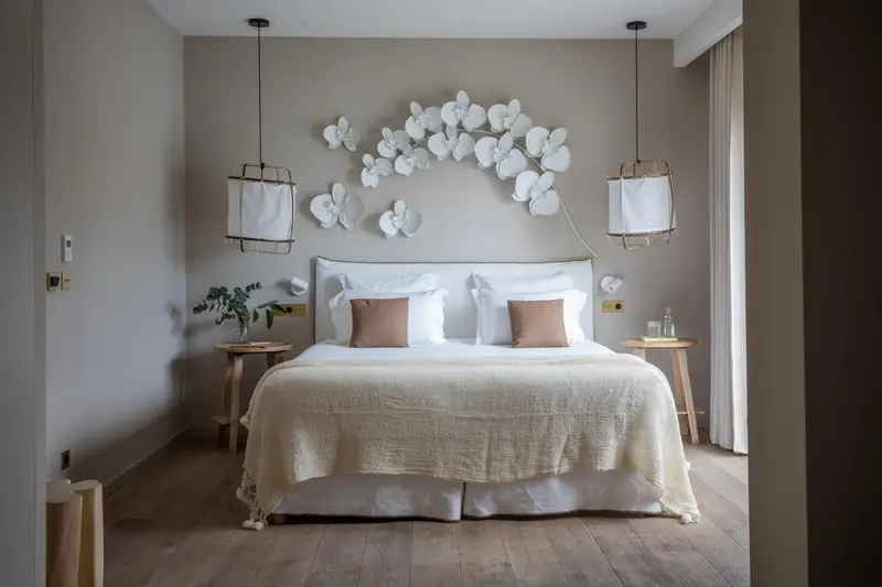 Une chambre lumineuse avec un grand lit recouvert d'une couverture texturée et décorée de coussins.