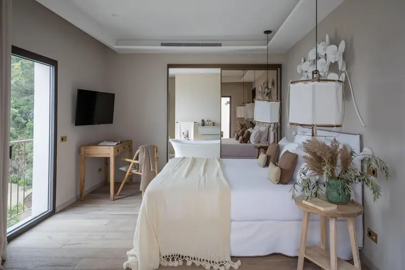 Une chambre lumineuse avec un grand lit et un bureau.