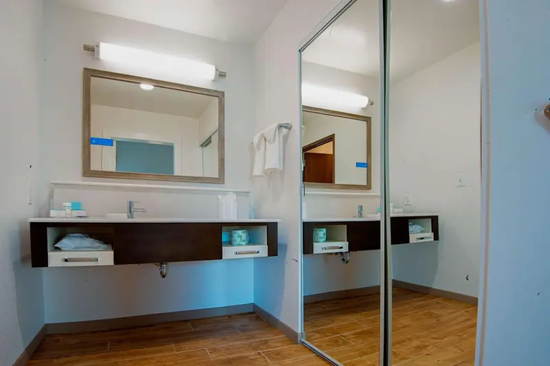 Une salle de bain moderne avec deux lavabos et des miroirs.