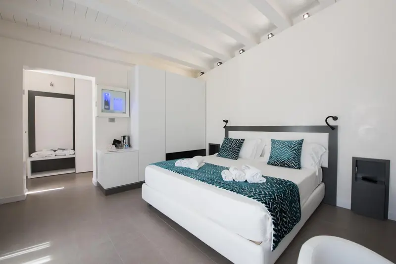 Une chambre lumineuse avec un grand lit et un espace détente.
