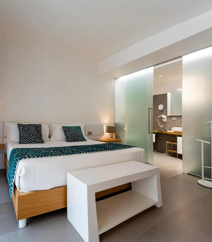 Une chambre lumineuse avec un grand lit et un accès à une salle de bain moderne.