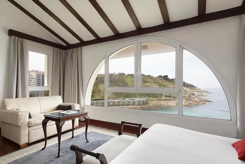 Une chambre lumineuse avec un canapé et une vue sur la mer.