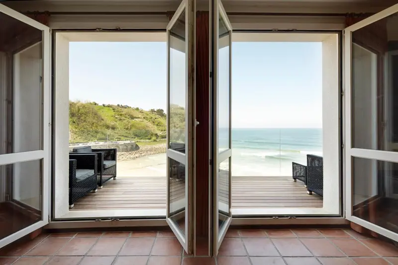 Vue sur la mer depuis une terrasse ensoleillée.