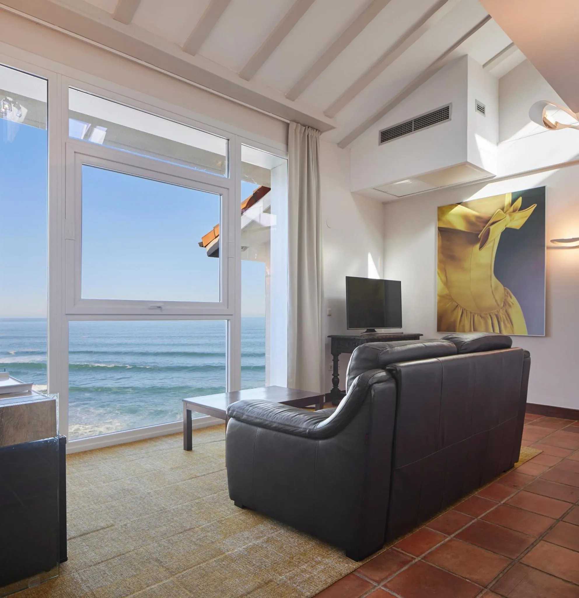 Un espace de détente intérieur avec canapés et vue sur la mer.