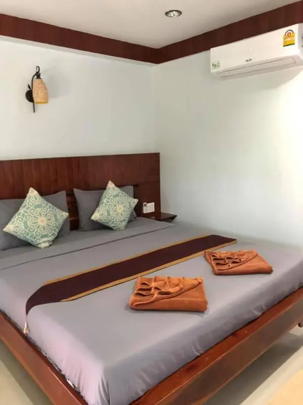 Une chambre avec un grand lit et des oreillers décorés.
