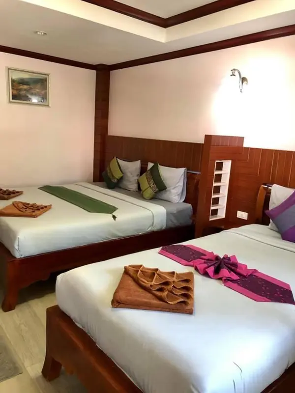 Deux lits jumeaux préparés dans une chambre d'hôtel.