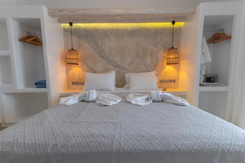 Lit double préparé avec soin dans une chambre lumineuse et décorée.