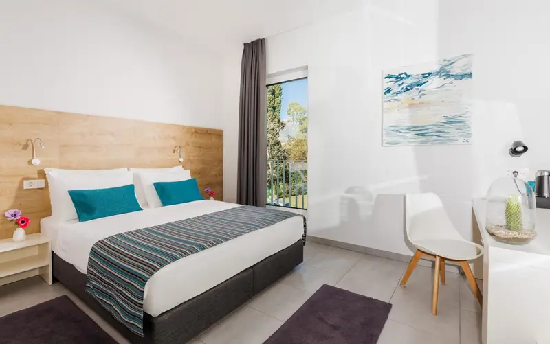 Une chambre lumineuse avec un grand lit et une décoration moderne.