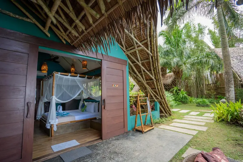 Une chambre avec un lit à baldaquin ouvert sur une terrasse.