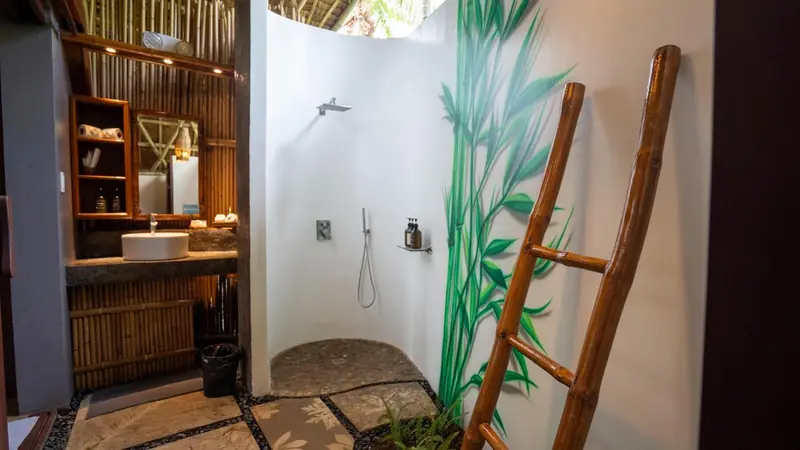 Douche à l'italienne dans une salle de bain ouverte sur l'extérieur.