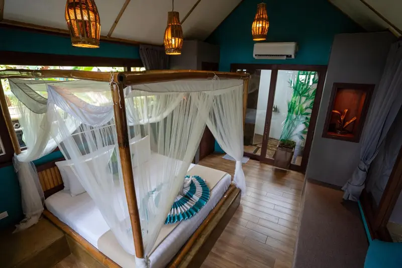 Une chambre avec un lit à baldaquin et une décoration tropicale.