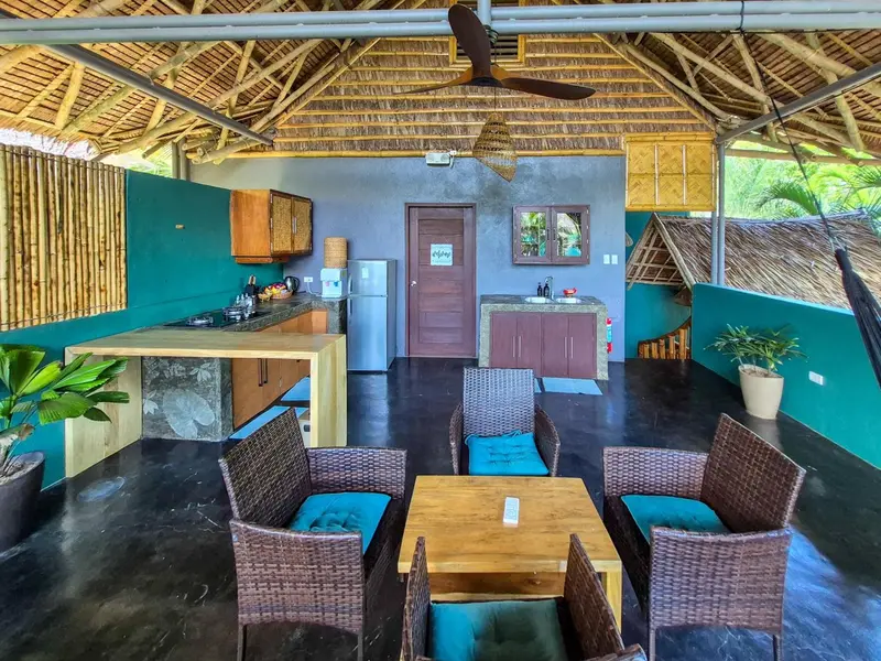 Une cuisine ouverte sur un espace repas avec mobilier en rotin.